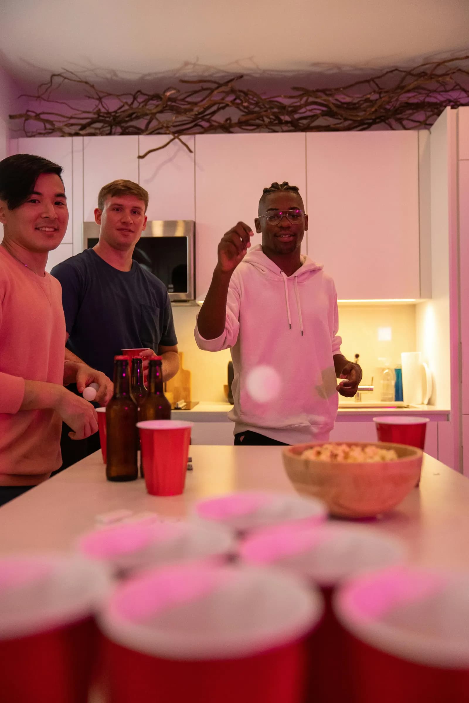 Group of men laughing together on a night out, the kind of crew that argues over who controls the music
